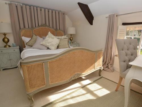 a bedroom with a large wicker bed and a window at 4 Bed in Dorchester 56025 in Piddletrenthide