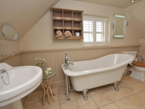 a bathroom with a tub and a sink and a toilet at 4 Bed in Dorchester 56025 in Piddletrenthide