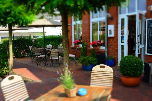 an outdoor patio with chairs and tables and plants at Klausdorfer Hof in Schwentinental