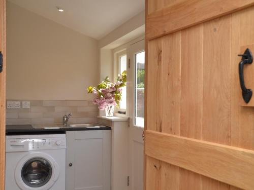 a laundry room with a washing machine and a window at 3 Bed in Cheddar 58129 in Burrington