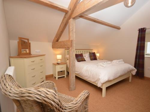 a bedroom with a bed and a dresser and two chairs at 3 Bed in Cheddar 58129 in Burrington