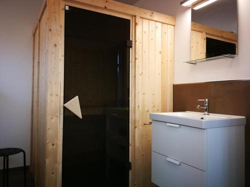 a bathroom with a sink and a wooden door at Ferienhaus Finja in Born in Born