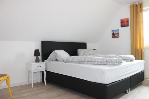 a bedroom with a bed with a black and white mattress at Ferienhaus Svea in Born in Born