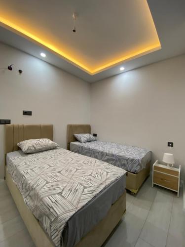 a bedroom with two beds and a night stand at Alp in Aksu