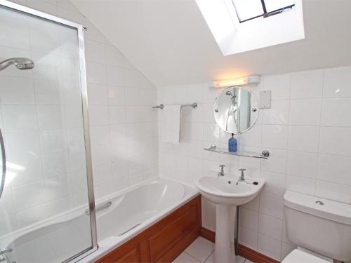 y baño con bañera, lavabo y espejo. en 4 Bed in Nr Bamburgh CN201, en Warenford