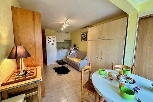 a kitchen and living room with a table and a room at L'Orée de Camargue Studio avec Cour in Le Grau-du-Roi