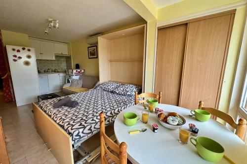 a room with a table and a kitchen with a bed at L'Orée de Camargue Studio avec Cour in Le Grau-du-Roi