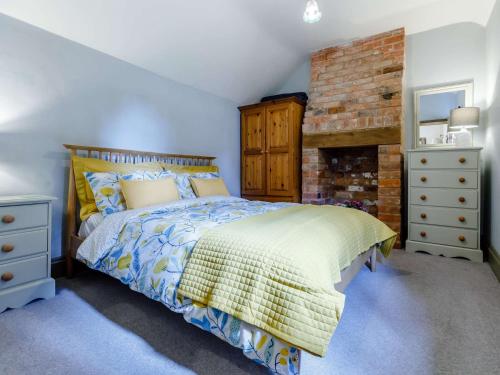 1 dormitorio con 1 cama y chimenea de ladrillo en 1 Bed in Gloucester 46502 en Lassington