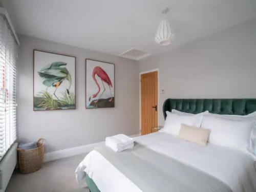 1 dormitorio con 1 cama blanca grande y 3 cuadros en la pared en Central Victorian terraced house Patio Garden - Pass the Keys, en Cheltenham