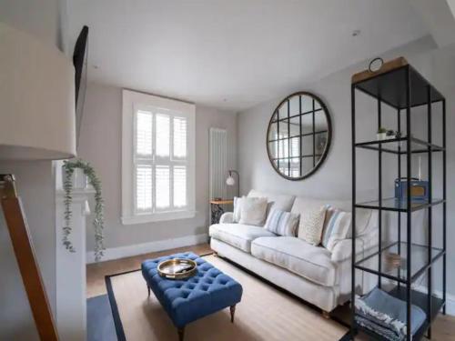 ein Wohnzimmer mit einem weißen Sofa und einem Spiegel in der Unterkunft Central Victorian terraced house Patio Garden - Pass the Keys in Cheltenham