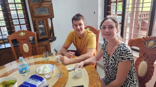 een man en een vrouw aan een tafel bij Pknhomestay kumily thekkady in Thekkady