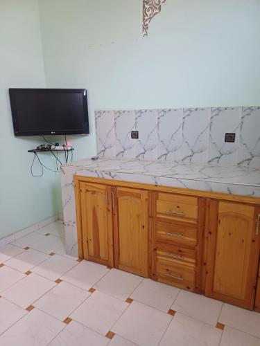 a room with a tv on a wall with a counter at Apartement privé in Taroudant