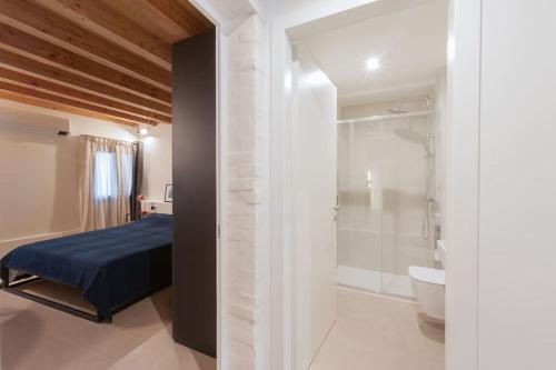 a bedroom with a bed and a bathroom with a shower at Ca' Ferrando, brand new apartment, experienced host! in Venice
