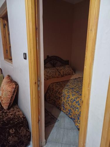 Habitación pequeña con 2 camas y puerta. en Apartement privé, en Taroudant