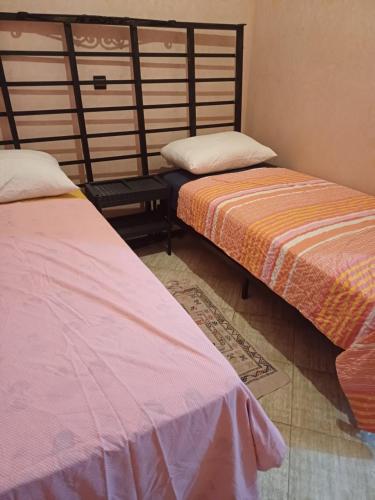 dos camas sentadas una al lado de la otra en una habitación en Apartement privé, en Taroudant