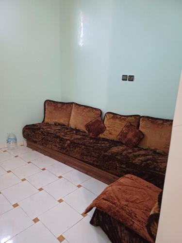 a brown couch in a room with a tile floor at Apartement privé in Taroudant