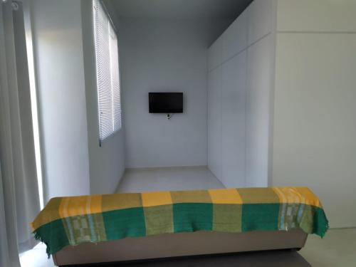 een slaapkamer met een bed met een geruite deken bij SEU LAR in Machadinho
