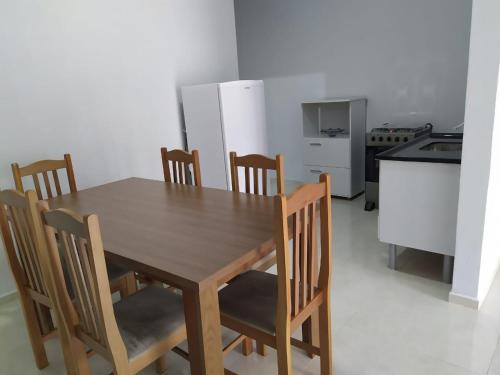 a dining room table with chairs and a kitchen at SEU LAR in Machadinho