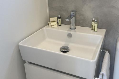 ein weißes Waschbecken im weißen Badezimmer mit in der Unterkunft Le Dune Villaggio in Lido Di Fondi