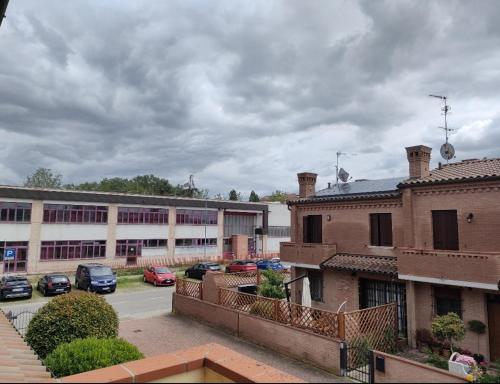 un estacionamiento con autos estacionados frente a un edificio en Casa Venere en Ferrara