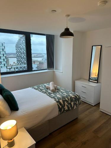 a bedroom with a bed and large windows at Stunning City View Apartment by Central Stay in Liverpool