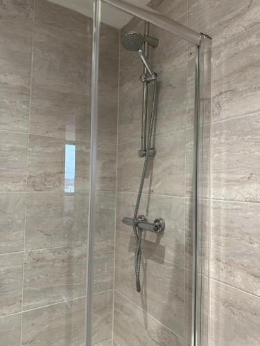 a shower with a glass door with a shower head at Stunning City View Apartment by Central Stay in Liverpool