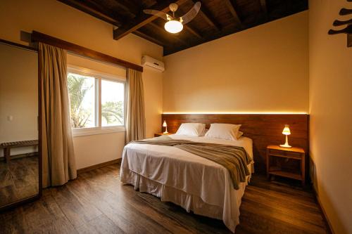 ein Schlafzimmer mit einem großen Bett und einem Fenster in der Unterkunft Fazenda Verde - Praia do Rosa in Praia do Rosa