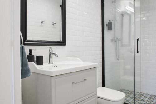 y baño blanco con lavabo y ducha. en Studio proche Roland Garros, en Boulogne-Billancourt