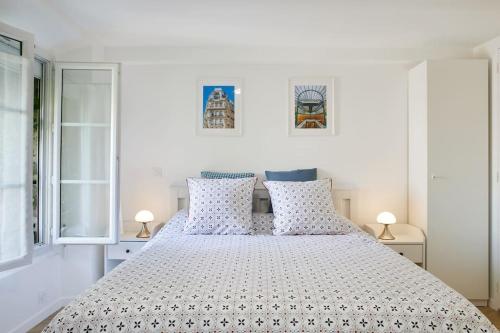 1 dormitorio blanco con 1 cama blanca grande con almohadas en Studio proche Roland Garros, en Boulogne-Billancourt