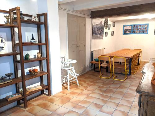 a dining room with a wooden table and chairs at Le cabinet de curiosités in Aiguèze