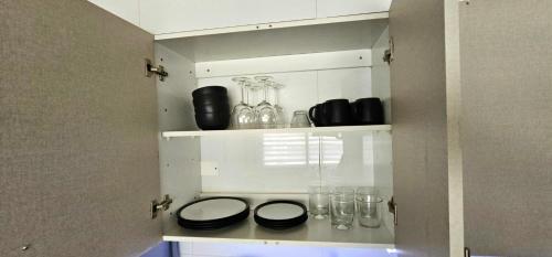 a cupboard with plates and glasses on it at moderno, acogedor departamento Vitacura Las Condes in Santiago