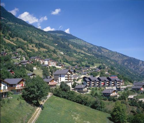 a village on a hill with houses and trees at Serviced Apartments Wallis in Mörel