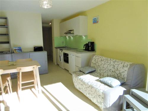 un salon avec un canapé et une cuisine dans l'établissement Appartement 2 à 4 personnes à 100 m de la mer - Gwendal, à Sarzeau