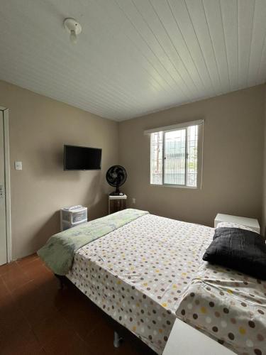 a bedroom with a large bed and a window at Casa Cachoeira do bom Jesus in Florianópolis