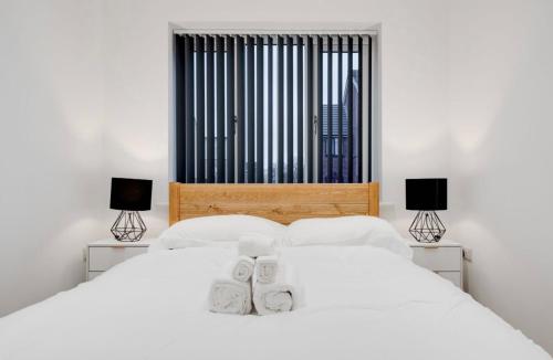 1 dormitorio con 2 camas y 2 lámparas en New Build Haven - Close to City Centre - Etihad, en Mánchester