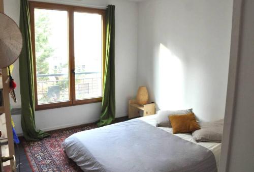 a bedroom with a bed and a window at Le Vendôme in Lyon