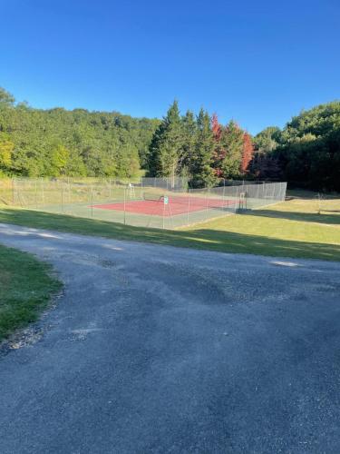 an empty tennis court with a tennis court at Chalet Janot in Mauroux