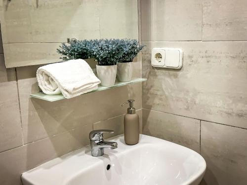 um lavatório de casa de banho com um dispensador de sabão ao lado em T2 Apartment -Cascais center - 100m from beach em Cascais