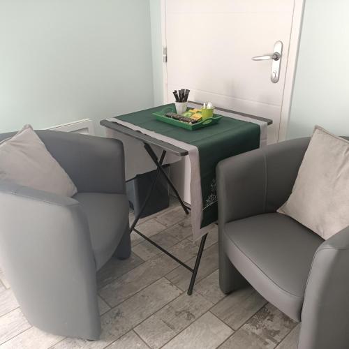 a room with two chairs and a table with a plate of food at Le balcon des cimes in Adast