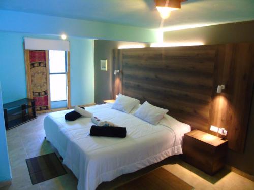 a bedroom with a large white bed with two bags on it at ASGARD Spa in San Agustín