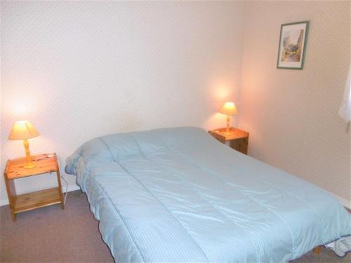 1 dormitorio con 1 cama azul y 2 lámparas en las mesas en Appartement 2 à 4 personnes à 50 m du port de St Jacques - Kolen, en Sarzeau