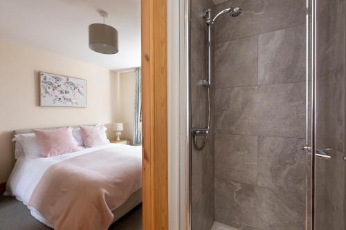 Schlafzimmer mit Dusche neben einem Bett in der Unterkunft Drumlanrig Mains Cottage in Thornhill
