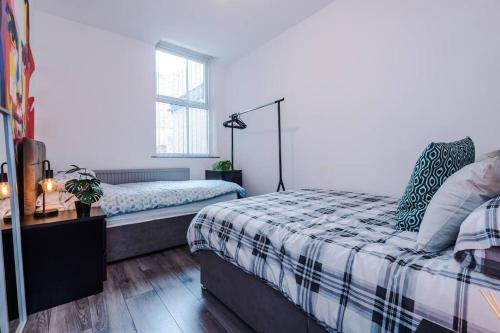 a bedroom with a bed and a desk and a window at LFC Themed Apartment in Liverpool