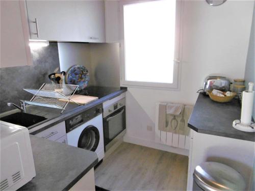 une cuisine avec un lave-linge et un lave-linge dans l'établissement Maisonnette 3 pièces 4 personnes à 200 m de la plage - wifi - LOMAN, à Sarzeau