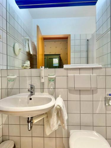 a bathroom with a sink and a toilet and a mirror at Gästehaus Weserblick am Weser-Sandstrand in Berne