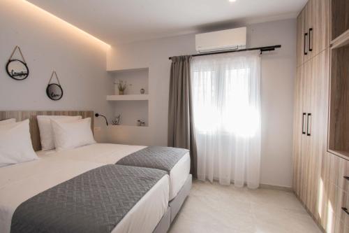 een slaapkamer met een groot bed en een raam bij Utopia Residences "by Checkin" in Chersonissos