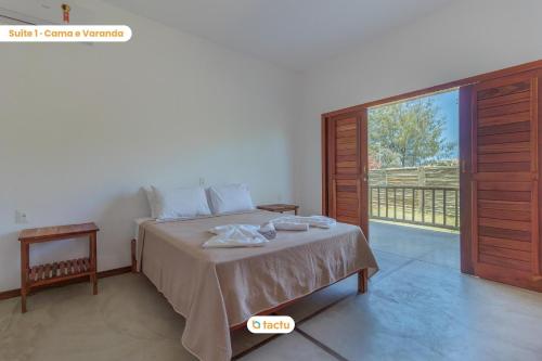 a bedroom with a bed and a sliding glass door at Apto 100m da praia no Pontal de Maceió por Tactu in Maceio
