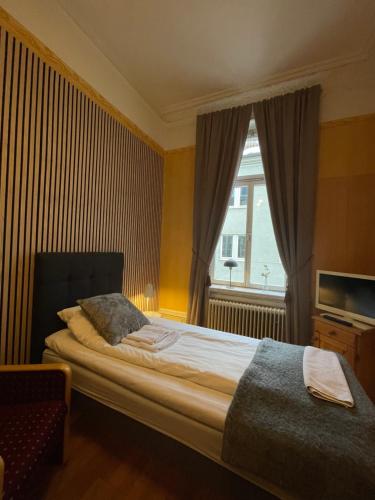 a bedroom with a large bed and a window at Lilla Hotellet in Sundsvall