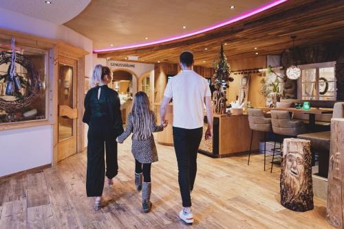 a man and a woman and a child walking through a store at Superior Sport und Familienresort Alpenblick in Zell am See