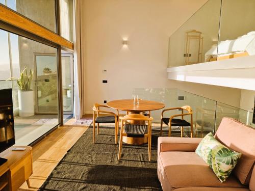 a living room with a table and chairs at SHELL LIVING - Infinity Loft in Funchal